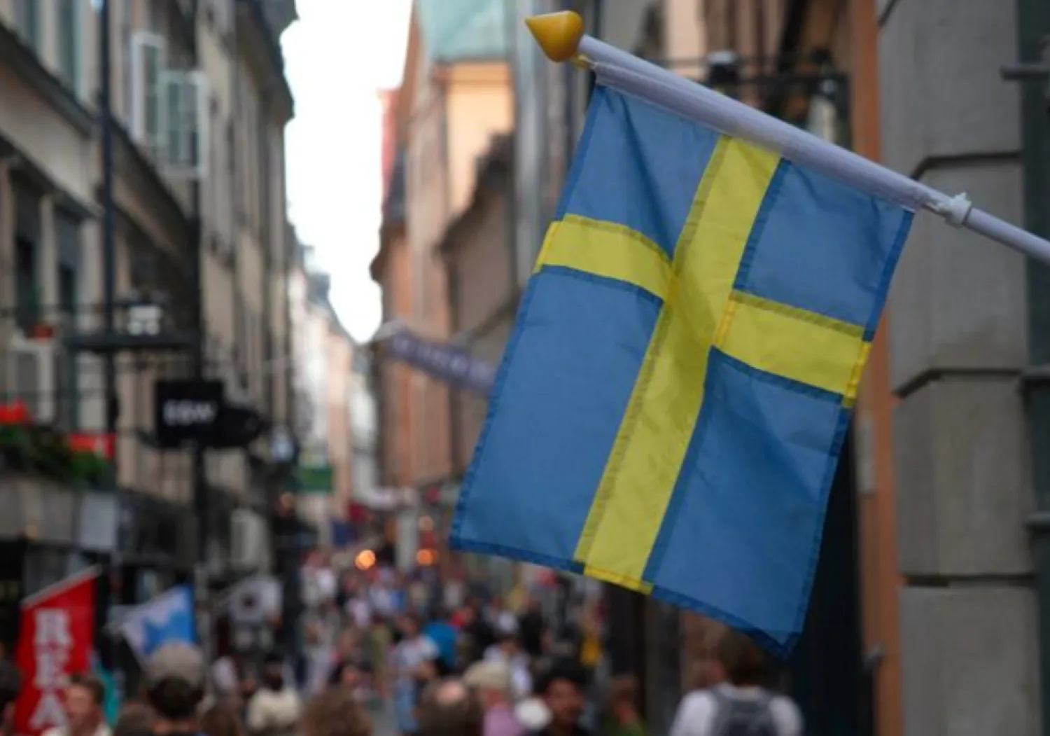 A Swedish flag hangs outside a store on a busy street as visitors walk past in the background in the old town of Stockholm, Sweden, July 14, 2023 REUTERS/Tom Little/File Photo Purchase Licensing Rights