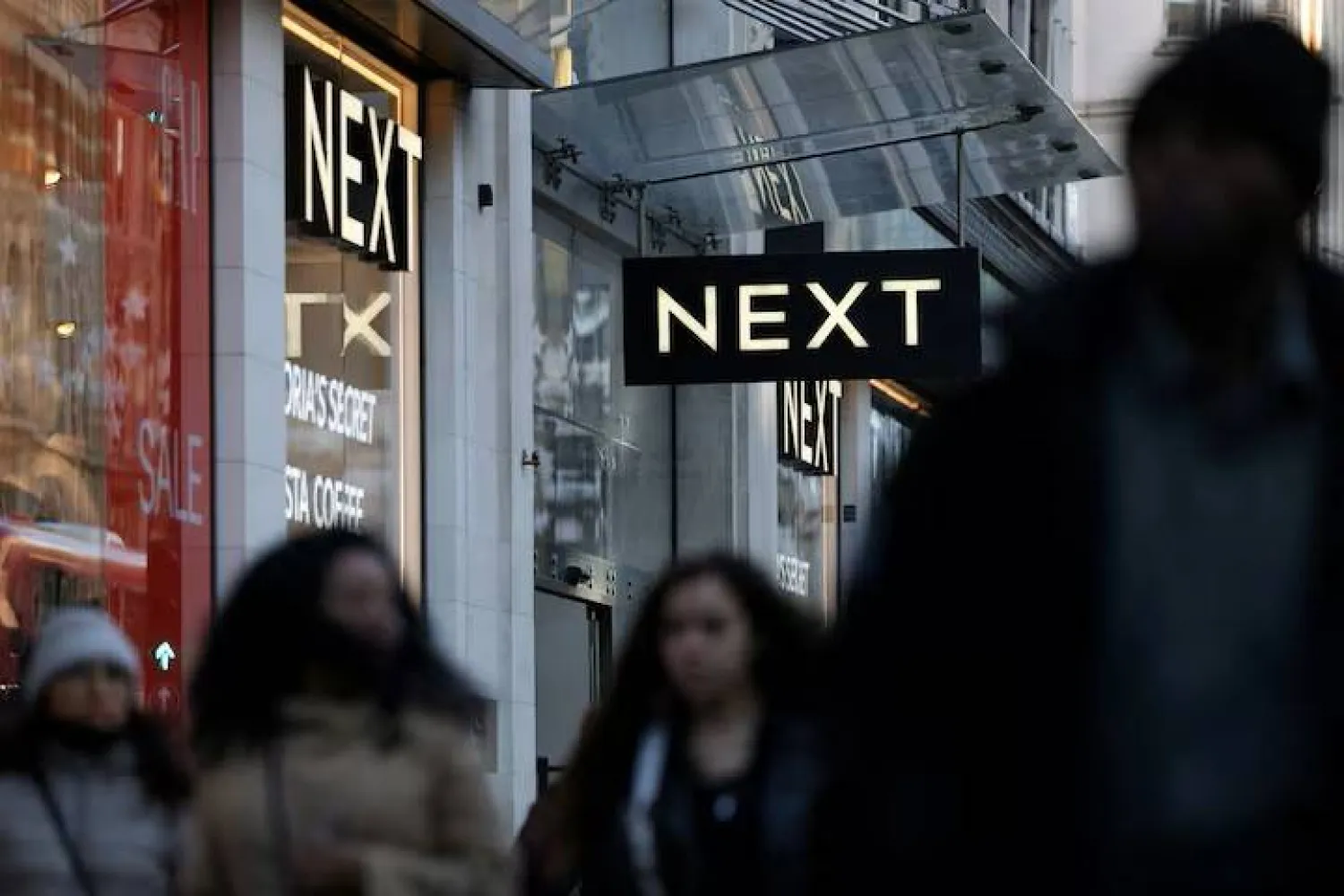 Shoppers walk past a NEXT retail store in London, Britain, January 2, 2025. REUTERS/Hollie Adams/File Photo