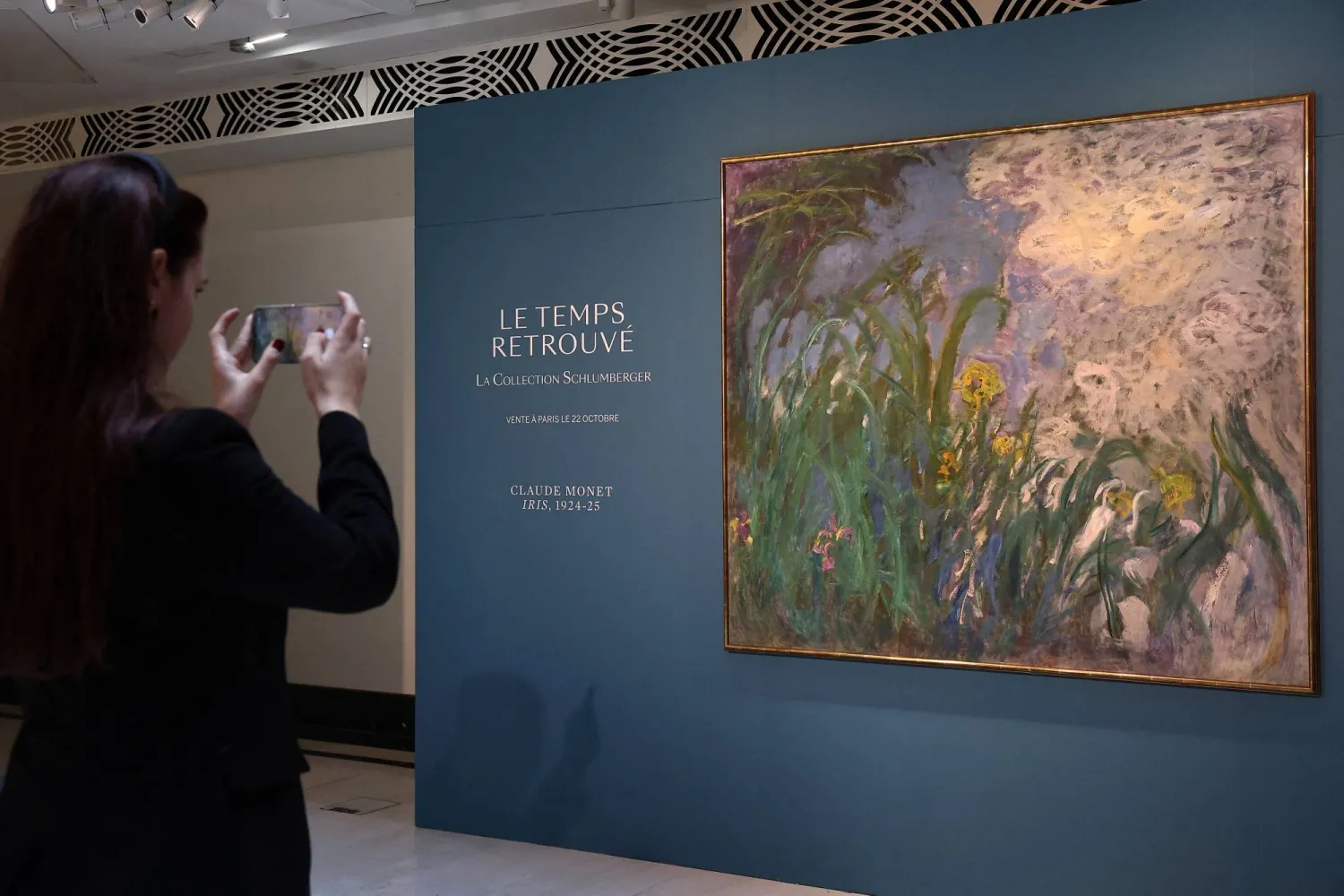 A visitor takes a picture of the painting "Iris, 1924-1925" by French painter Claude Monet (1840-1926) during the presentation of 28 art works from the Schlumberger Collection ahead of the auction at Sotheby's auction house in Paris, France, September 17, 2026. REUTERS/Abdul Saboor