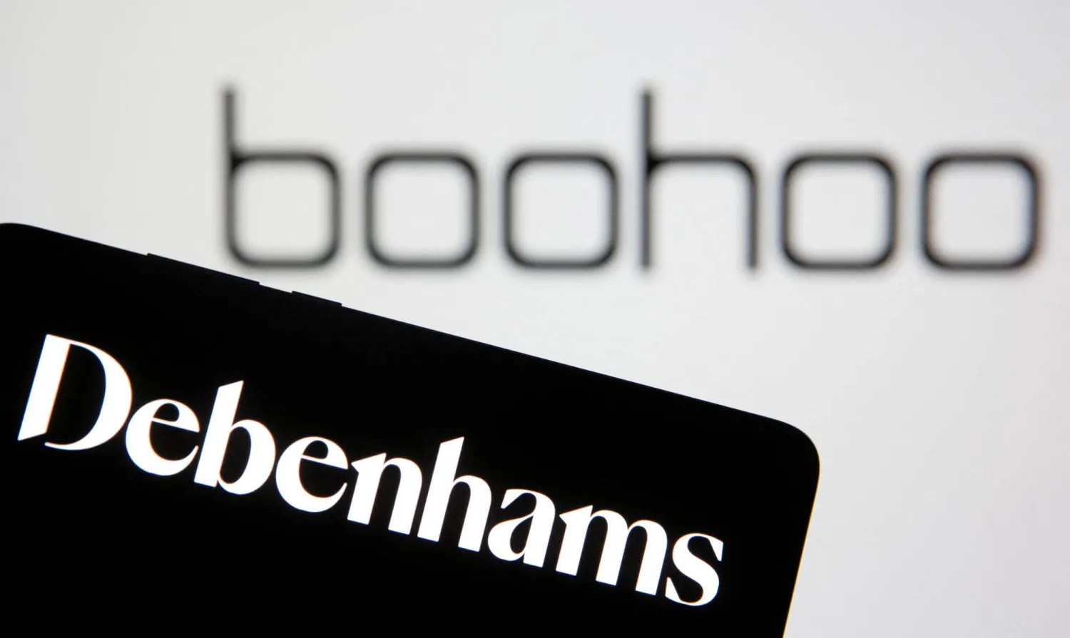 FILE PHOTO: Debenhams logo is seen on smartphone in front of a displayed Boohoo logo in this illustration taken January 25, 2021. REUTERS/Dado Ruvic/Illustration/File Photo