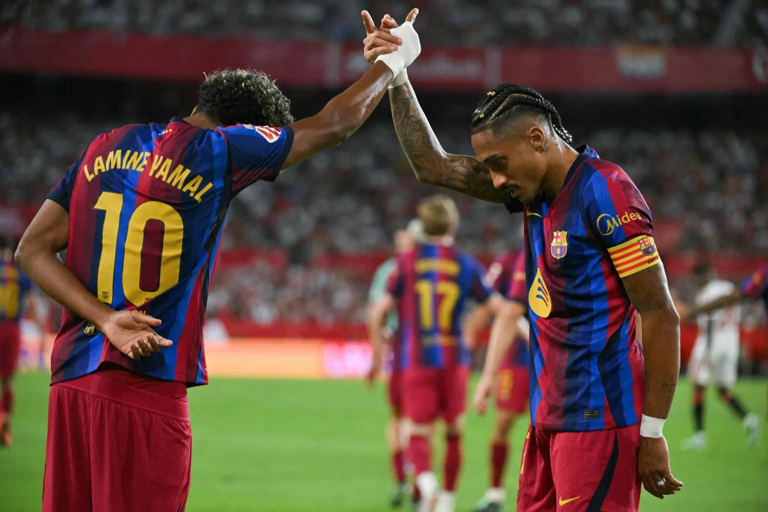 Barcelona's Brazilian forward #11 Raphinha (R) celebrates with teammate Spanish forward #10 Lamine Yamal after scoring his team's second goal during the Spanish league football match between Sevilla FC and FC Barcelona at the Ramon Sanchez Pizjuan stadium in Seville on September 19, 2026. (AFP)