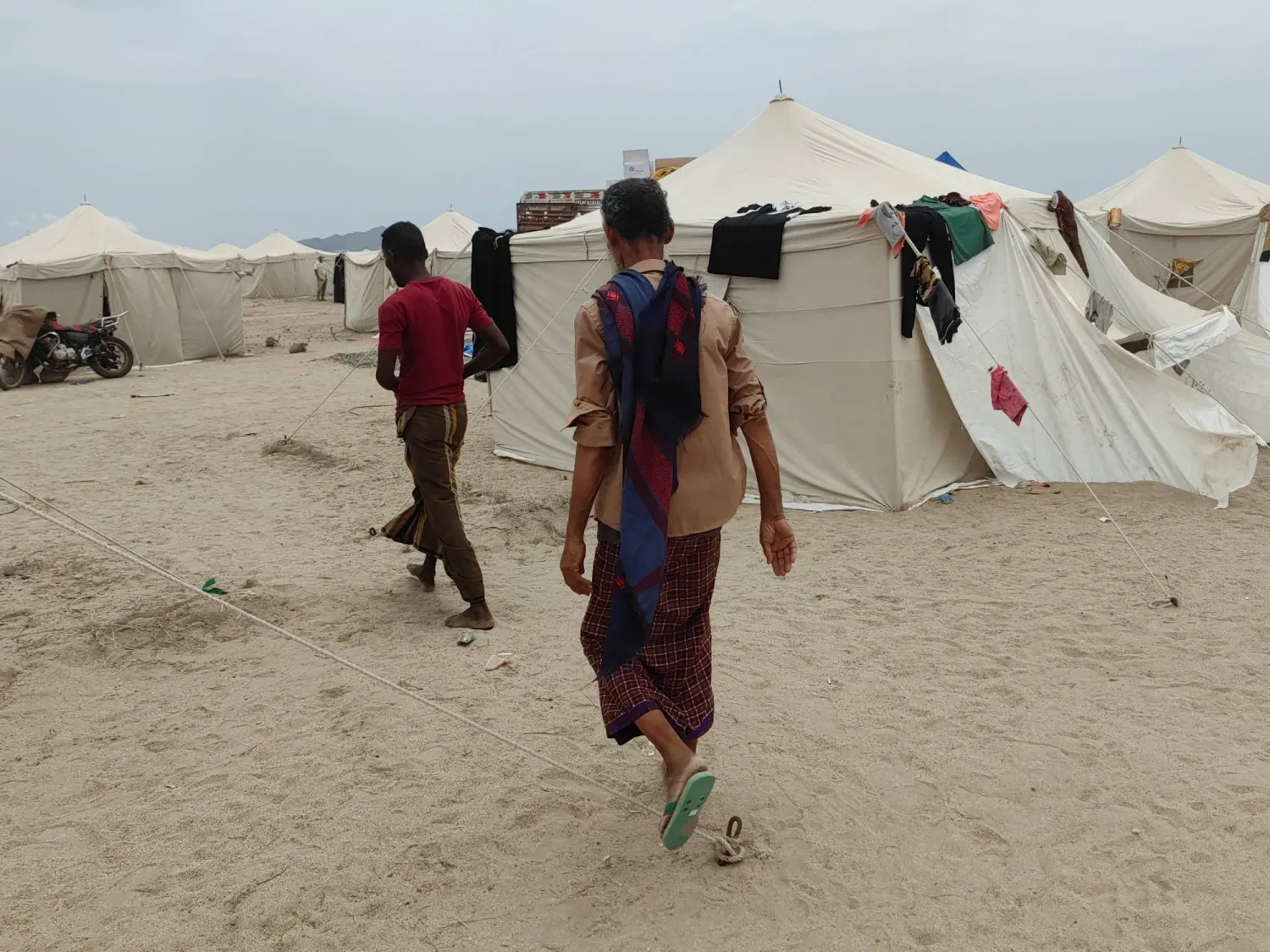  People walk past tents in al-Firdaws camp in Aden province, amid clashes between Iran-aligned Houthi fighters and Yemeni government forces, in Aden, Yemen, September 17, 2026. (Reuters)