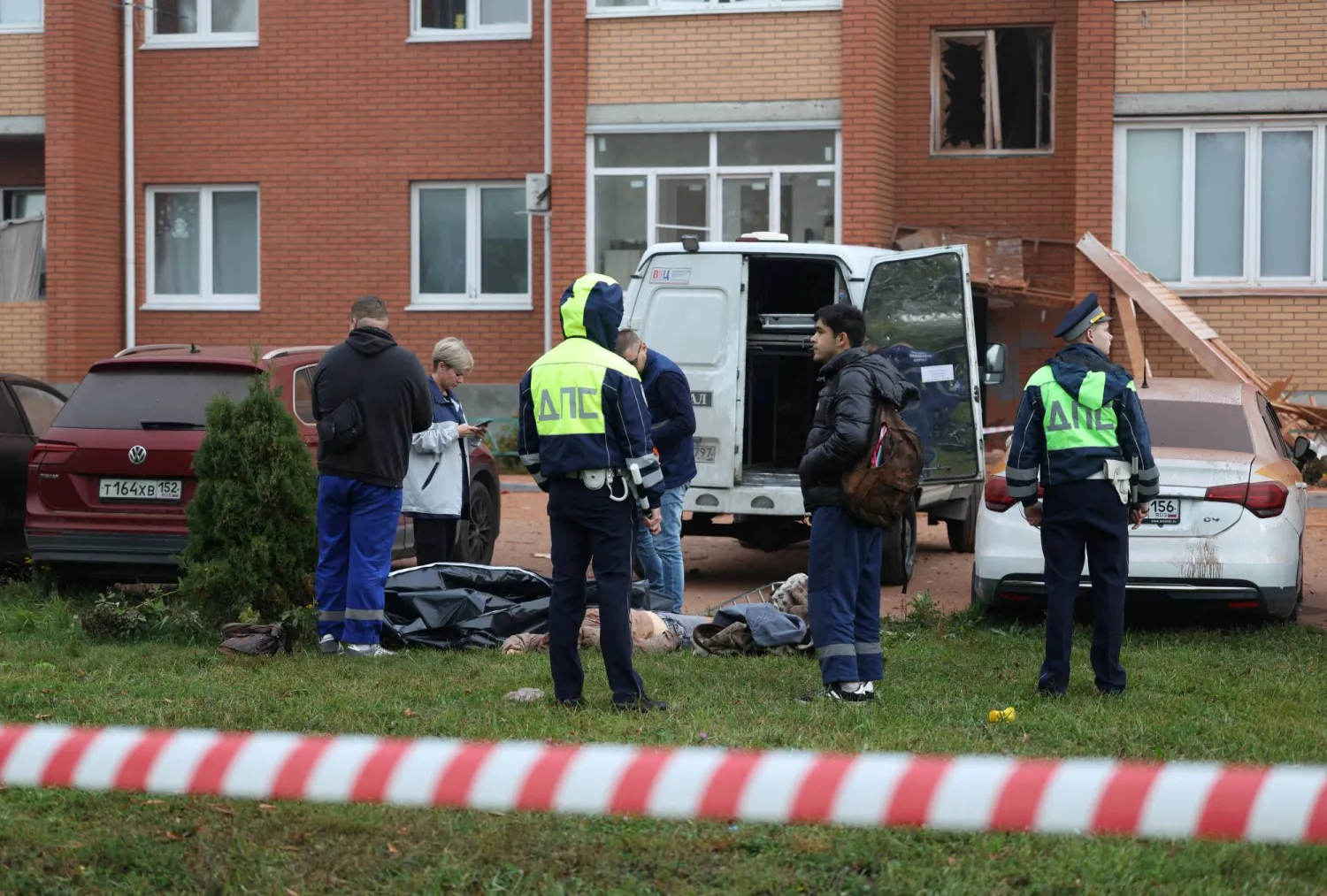Emergency services personnel stand around the body of a victim killed in what authorities described as a Ukrainian drone strike on a residential building, amid the Russia-Ukraine conflict in Sofyino settlement in the Ramensky district of the Moscow region, Russia, September, 20, 2026. REUTERS/Stringer
