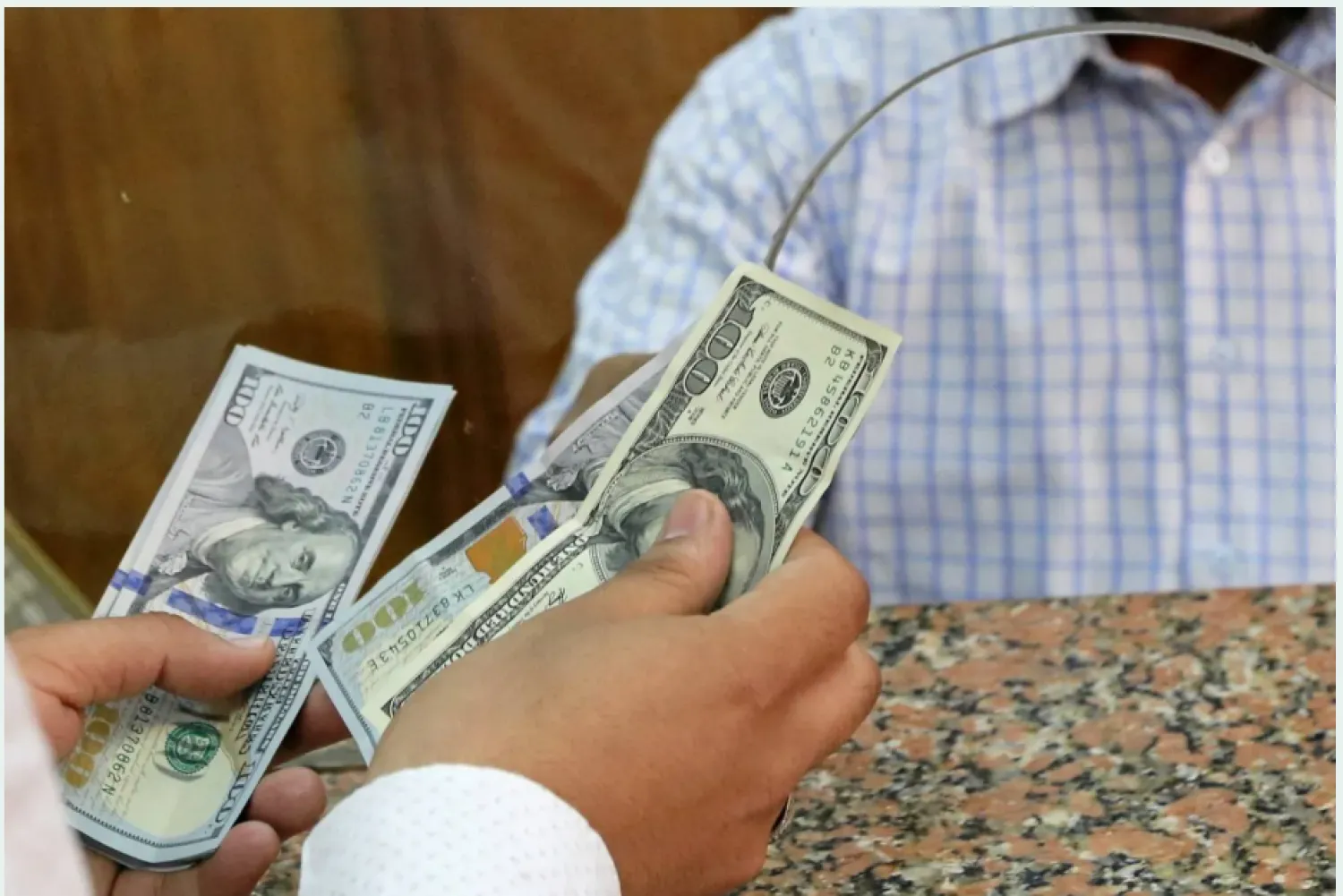 مواطن يستبدل دولارات داخل مكتب صرافة وسط القاهرة (رويترز)