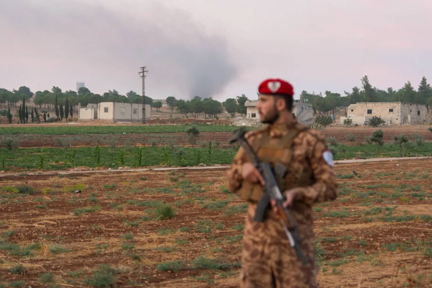 Halep’in güney kırsalındaki el-İys bölgesinde bir silah deposunda meydana gelen patlamanın ardından bir askeri polis memuru yol üzerinde bekliyor (Reuters)