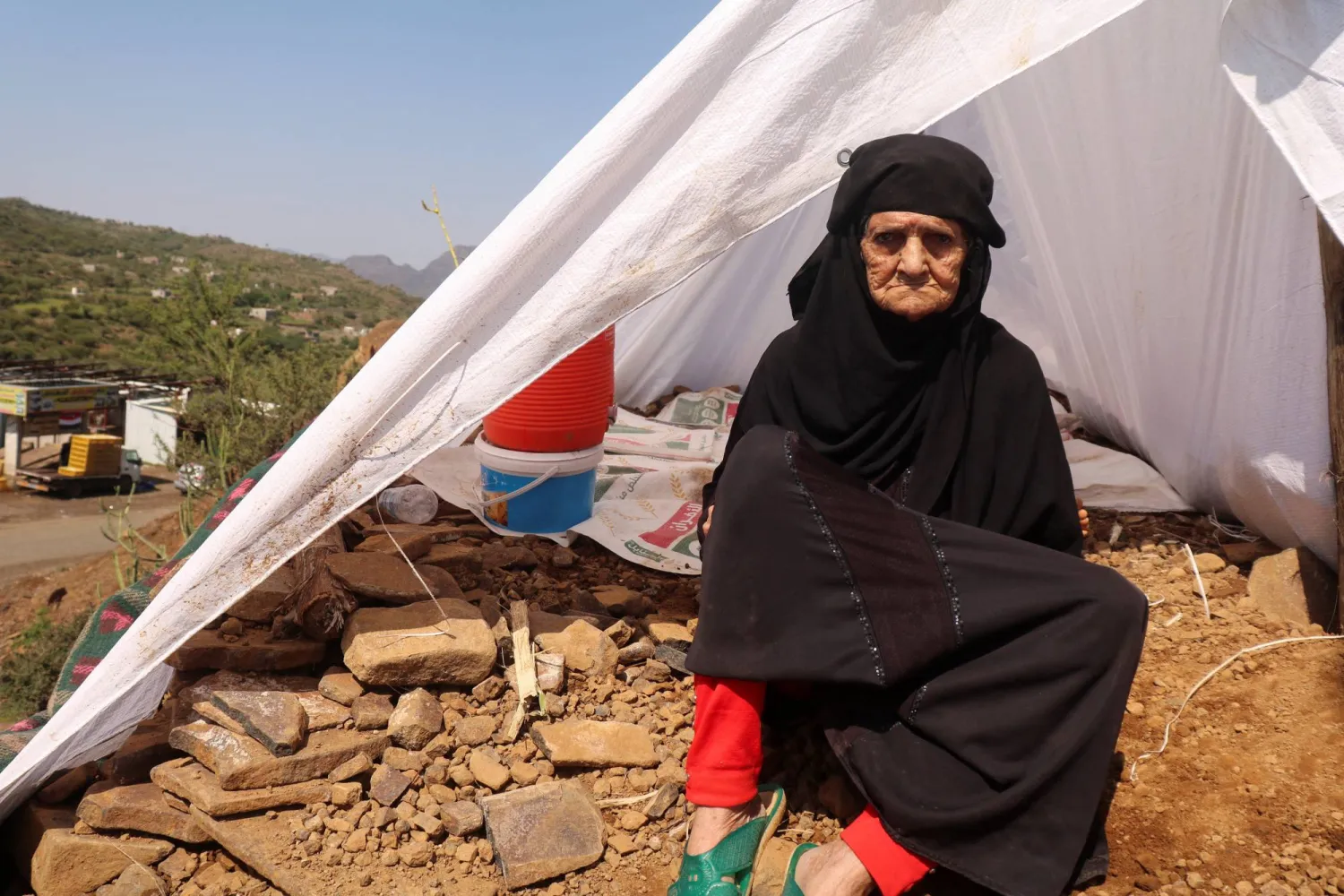  A displaced woman sits outside her tent at a makeshift camp for people displaced by clashes between Iran-aligned Houthi fighters and Yemeni government forces, in Taiz province, Yemen September 21, 2026. (Reuters)