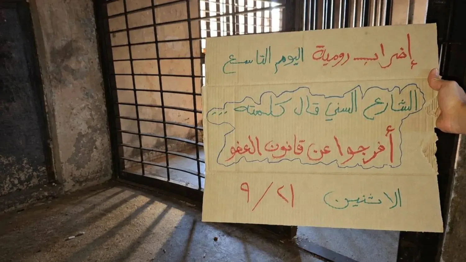 A sign held by a protester at Roumieh Prison calls for the implementation of the General Amnesty Law (Al-Markazia)
