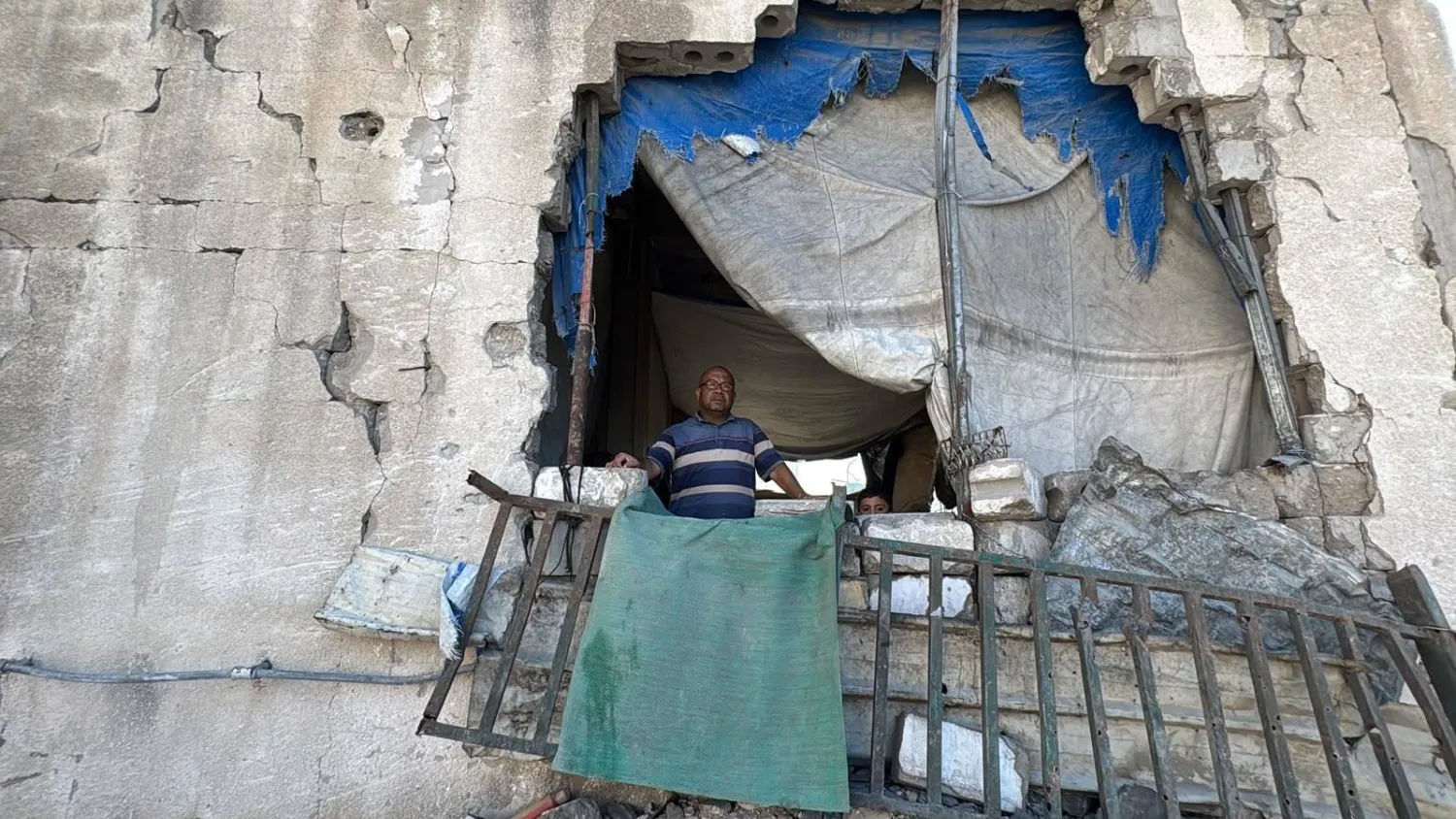 الفلسطيني بسام نصير النازح في مدينة غزة يقف بين أنقاض مبنى متهدم يؤويه وعائلته (الشرق الأوسط)