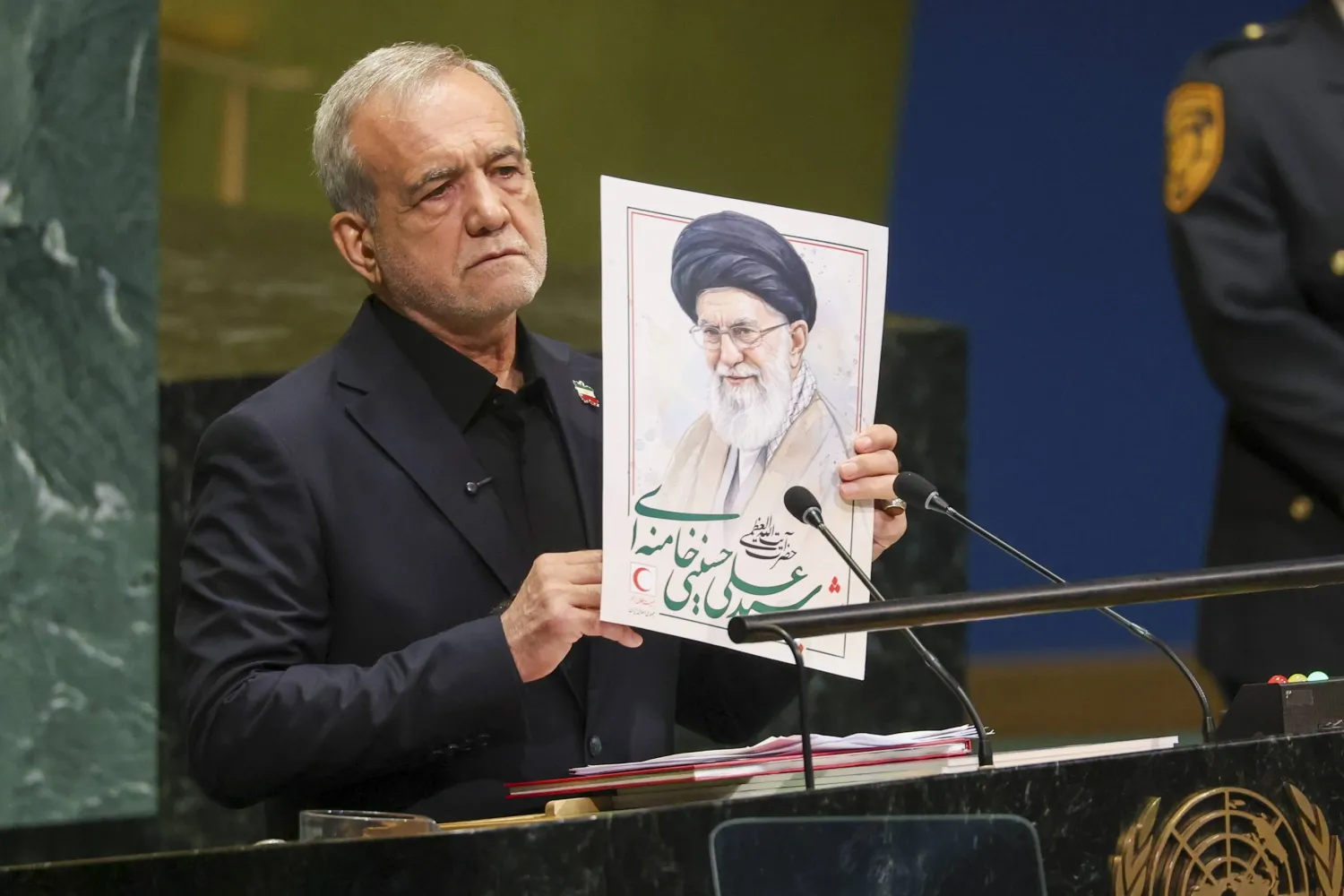 بزشكيان رافعاً صورة علي خامنئي في الأمم المتحدة (رويترز)