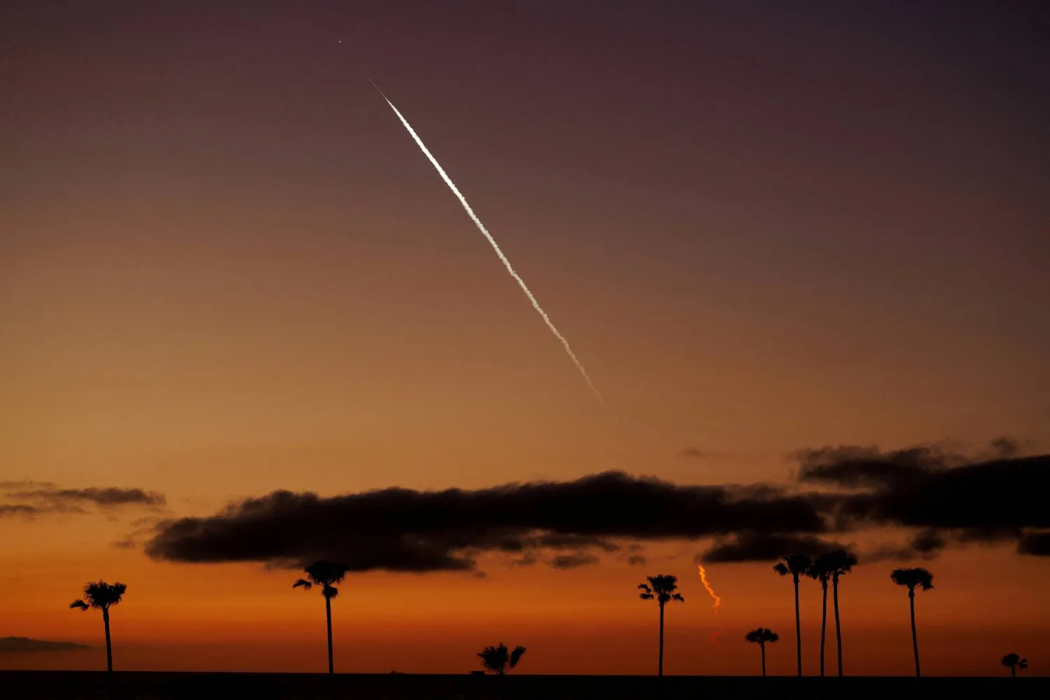FILE PHOTO: An evening launch of a SpaceX Falcon 9 rocket carrying 22 Starlink satellites to low-Earth orbit is seen over the Pacific Ocean from Encinitas, California, US, April 1, 2024.  REUTERS/Mike Blake/File Photo
