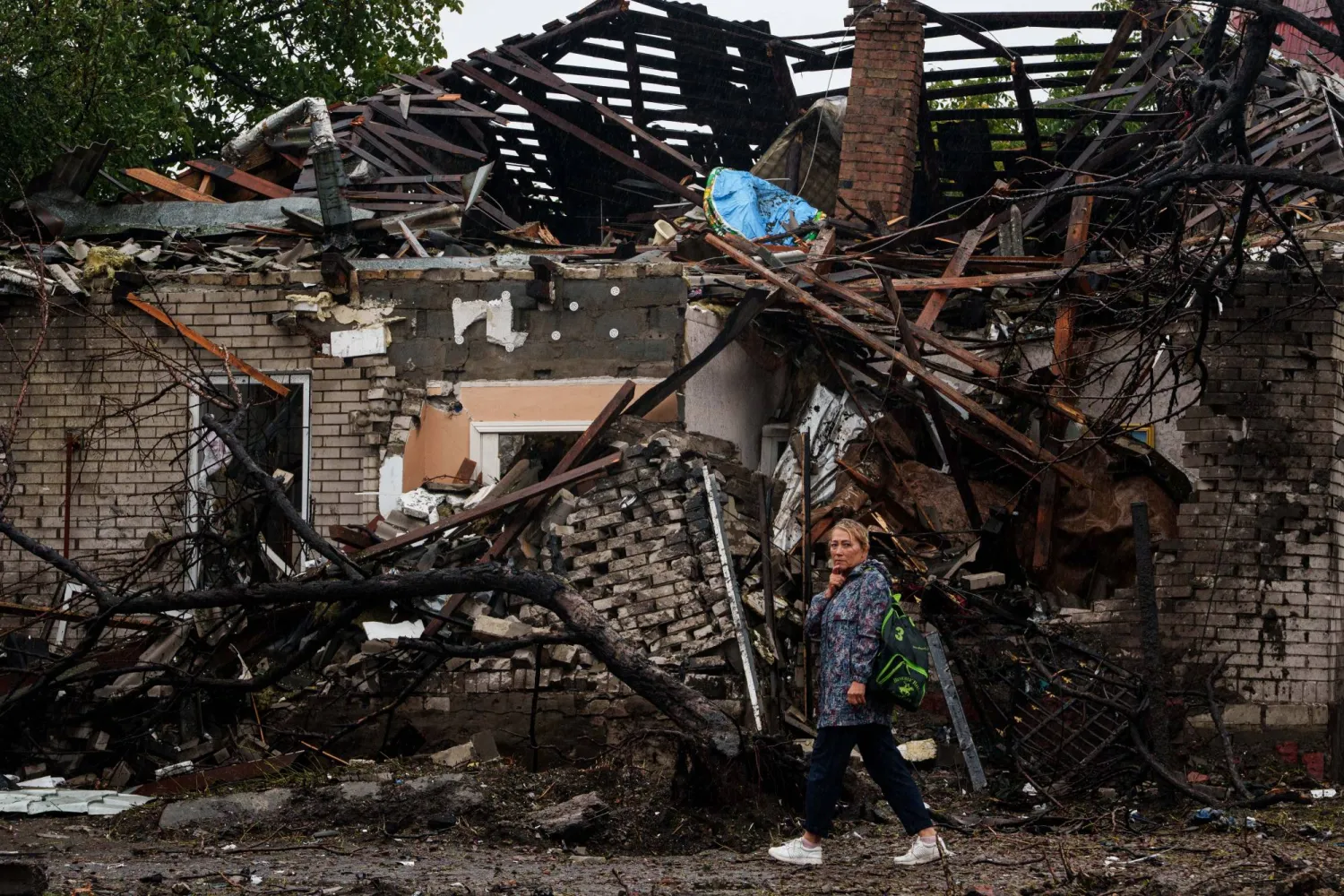 A woman walks in front of a house destroyed in a Russian strike on a residential neighbourhood in Kyiv, Ukraine, Thursday, Sept. 24, 2026. (AP Photo/Evgeniy Maloletka)