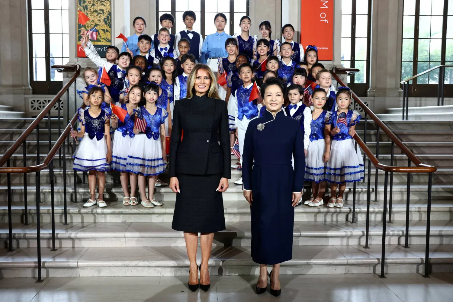 First lady of China Peng Liyuan and US first lady Melania Trump pose for a photo with children during a visit to the Smithsonian's National Museum of Asian Art from Director of the museum Chase Robinson in Washington, DC, US, September 24, 2026. (Reuters)