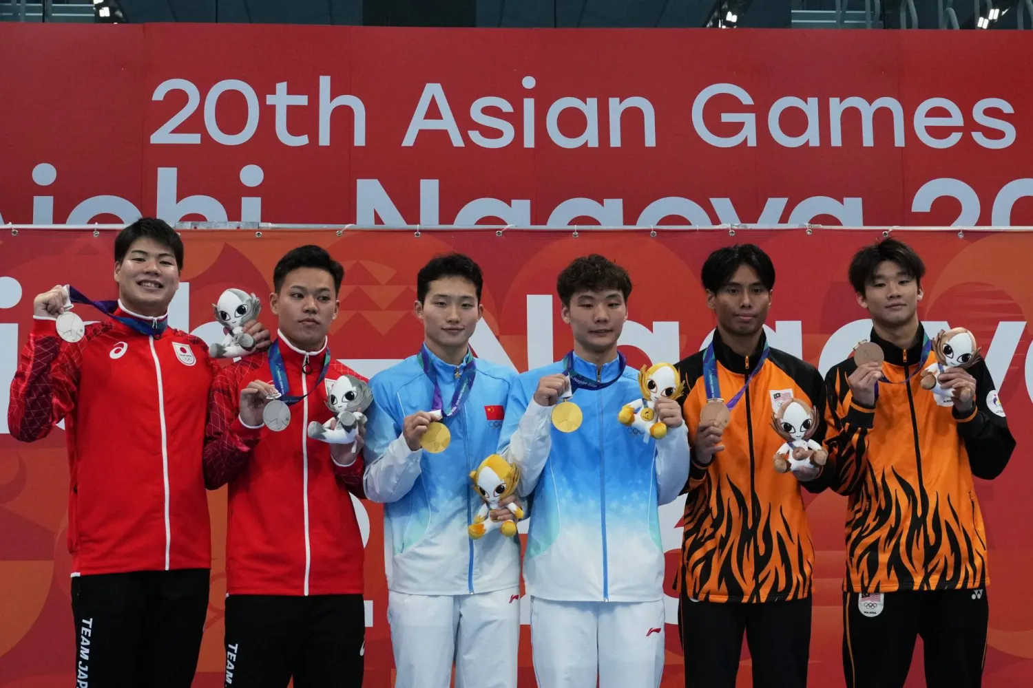 Gold medalists Wang Zongyuan and Zheng Jiuyuan of China, center, flanked by silver medalists Senri Ikuma and Haruki Suyama of Japan, left, and bronze medalist Rui Jie Yong and Nurgayyum Mohamad of Malaysia pose on the podium after the men's synchronized 3m springboard final at the Asian Games in Tokyo, Japan, Saturday, Sept. 26, 2026. (AP Photo/Hiro Komae)