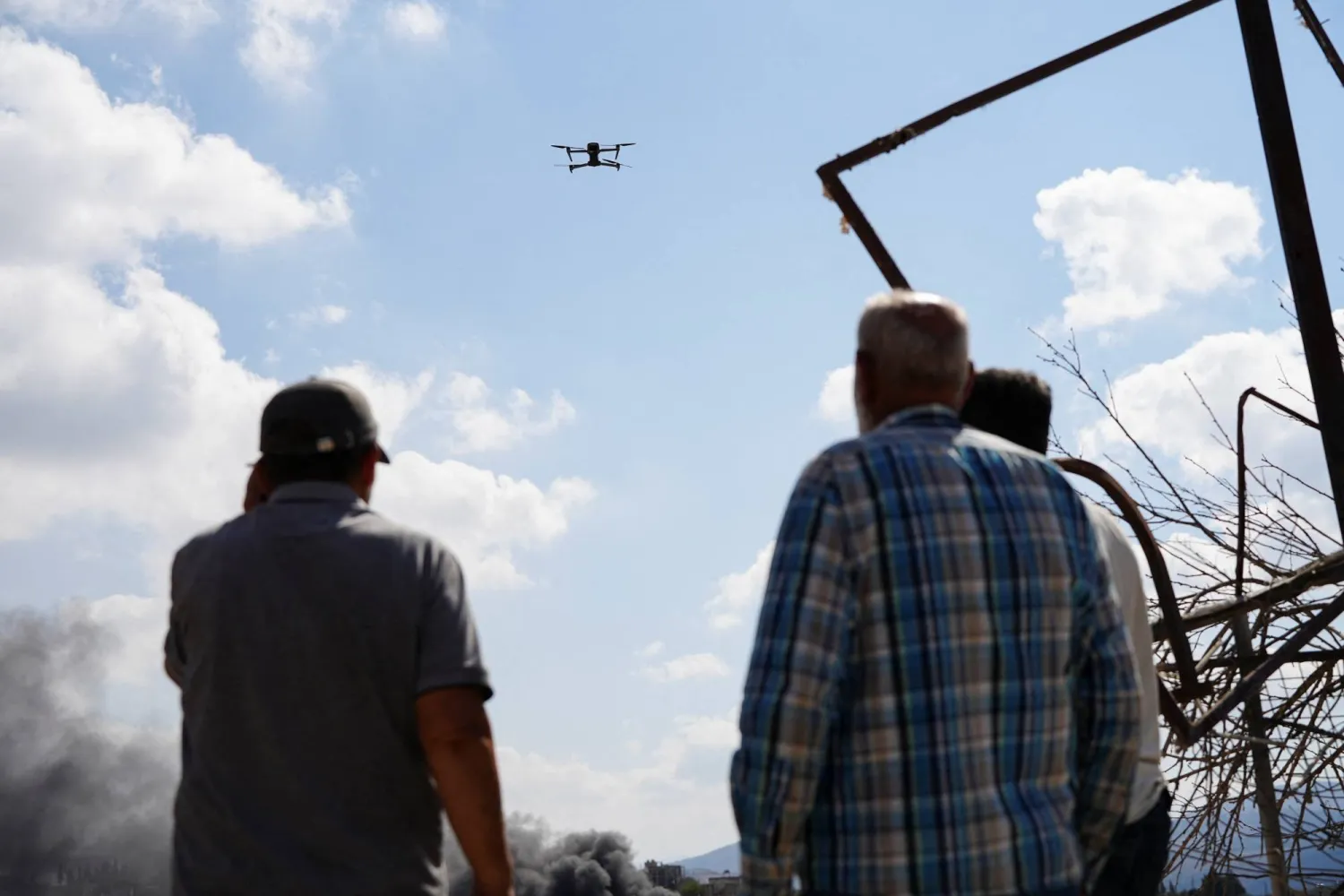 Local residents watch an Israeli drone monitoring them in the South Lebanon town of Zawtar al-Gharbiya. (Reuters) 