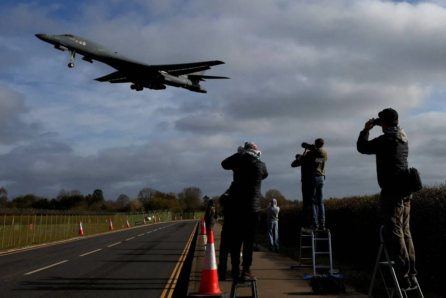 People use their cameras as a USAF B-1 bomber approaches to land at RAF Fairford airbase, used by United States Air Force (USAF) personnel, amid the US–Israeli conflict with Iran, in Fairford, Gloucestershire, Britain, March 17, 2026. REUTERS/Toby Melville/File Photo