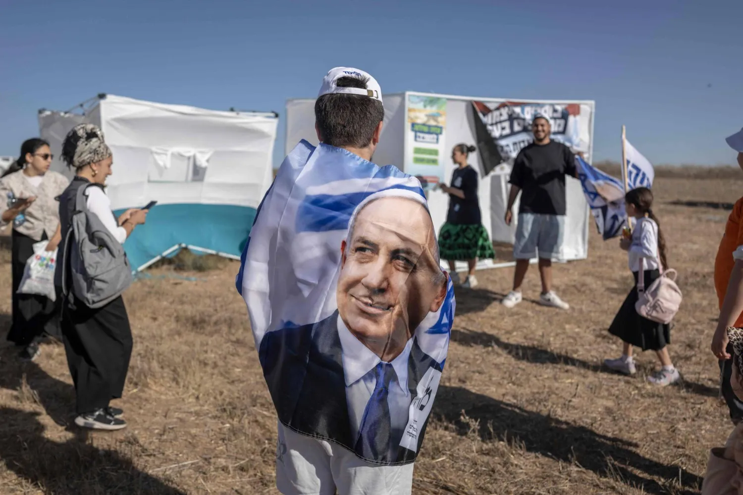  Israeli right-wing activists supporting Prime Minister Benjamin Netanyahu gather for the Jewish holiday of Sukkot, the Feast of the Tabernacles, in a field outside Kibbutz Nir-Am by the Israel-Gaza border on September 27, 2026. (AFP) 
