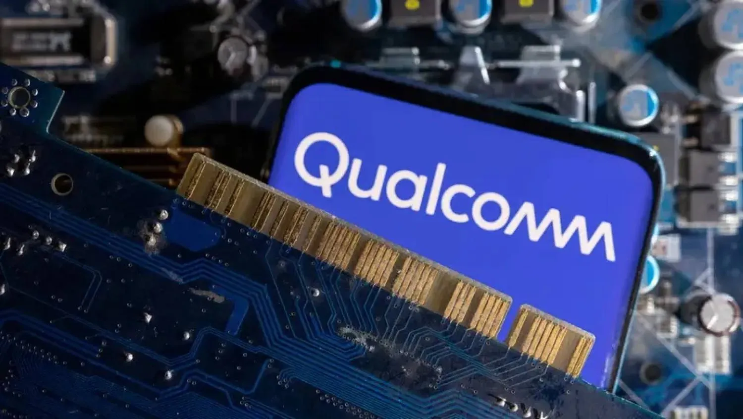 A smartphone with a displayed Qualcomm logo is placed on a computer motherboard in this illustration taken March 6, 2023. REUTERS/Dado Ruvic/Illustration 