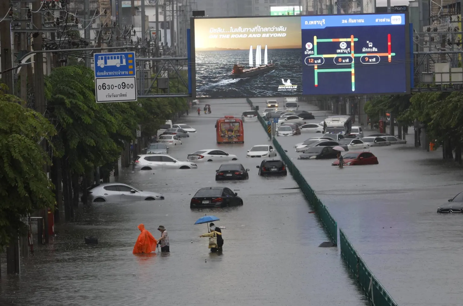 People wade through floodwater as submerged vehicles remain abandoned along Phetchaburi Road in Bangkok, Thailand, 26 September 2026. EPA/RUNGROJ YONGRIT
