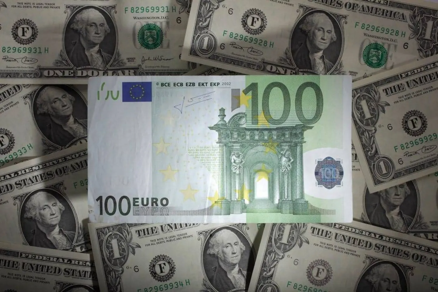 ورقة نقدية من فئة 100 يورو فوق أوراق نقدية من فئة دولار واحد في وارسو (رويترز)
