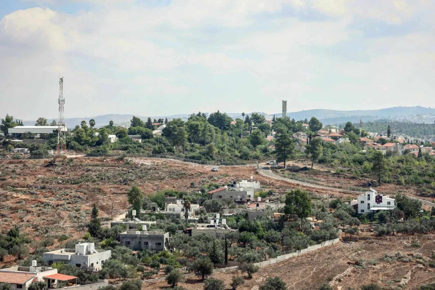  The Israeli settlement of Halamish is seen on a hill overlooking Palestinian homes in the village of Deir Nidham, northwest of Ramallah, in the Israeli-occupied West Bank, on September 23, 2026. (AFP) 