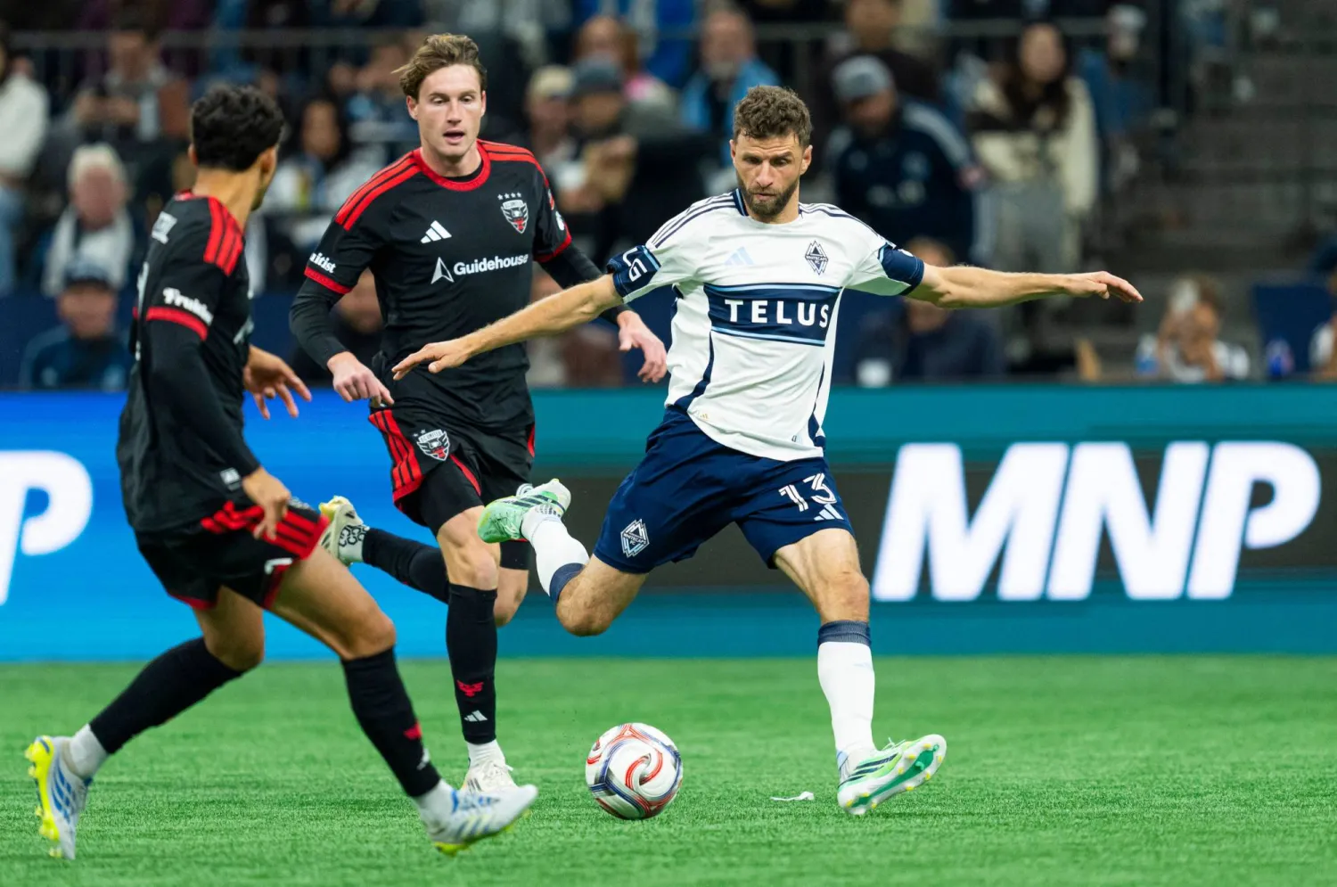 Thomas Muller #13 of the Vancouver Whitecaps FC takes a shot on goal while being defended against by Andre Dozzell #21 and Kye Rowles #15 of DC United during the second half of MLS action at BC Place on September 26, 2026 in Vancouver, Canada. (Getty Images/AFP)