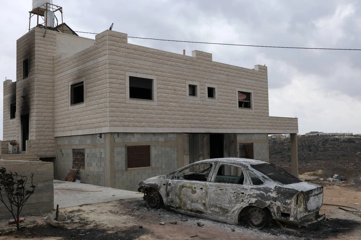 A burned-out car stands outside a damaged building in the West Bank village of Jalud, south of Nablus, 29 September 2026. (EPA)