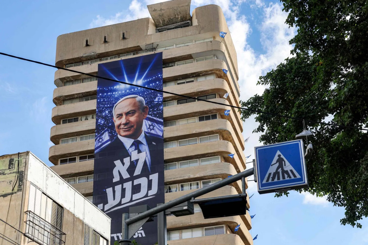 A giant electoral poster for Israeli Prime Minister Benjamin Netanyahu's Likud party with the slogan "no surrender" is displayed on the facade of a building in Tel Aviv on September 29, 2026 during campaigns ahead of the October 2026 legislative elections. (AFP)