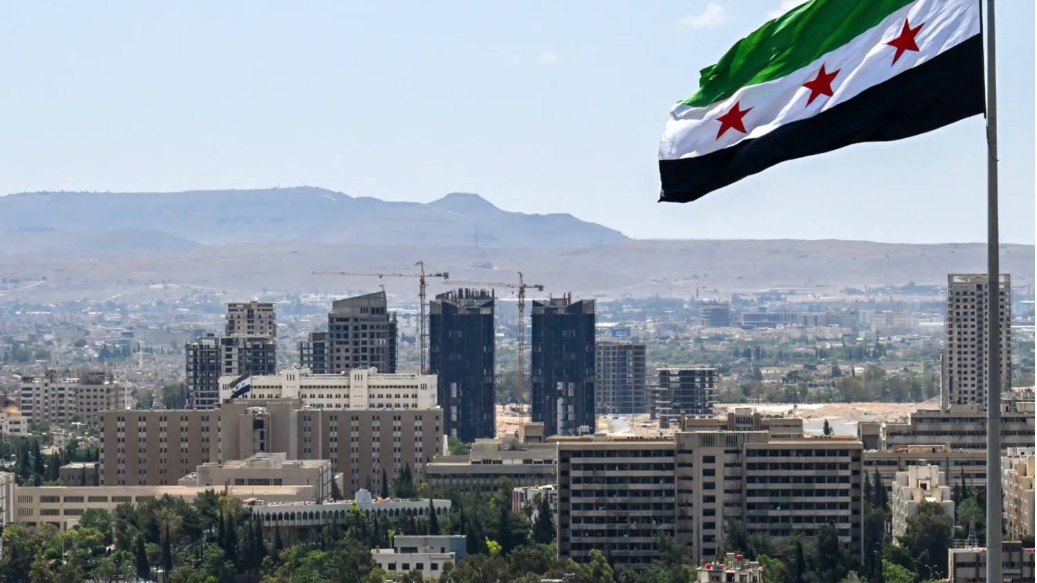 A large Syrian flag flutters above Tishreen Park in Damascus on June 4, 2025. (AFP)
