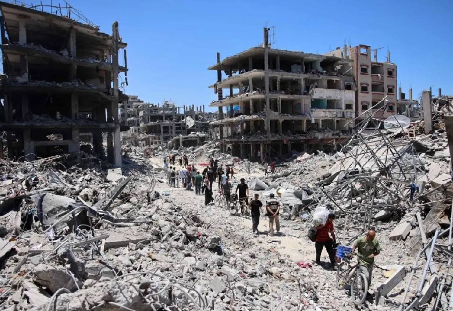 Palestinians carry some salvaged belongings as they leave the Jabalia refugee camp in the northern Gaza Strip after they returned briefly to check on their homes on May 31, 2024, amid the ongoing conflict between Israel and Hamas. (AFP)