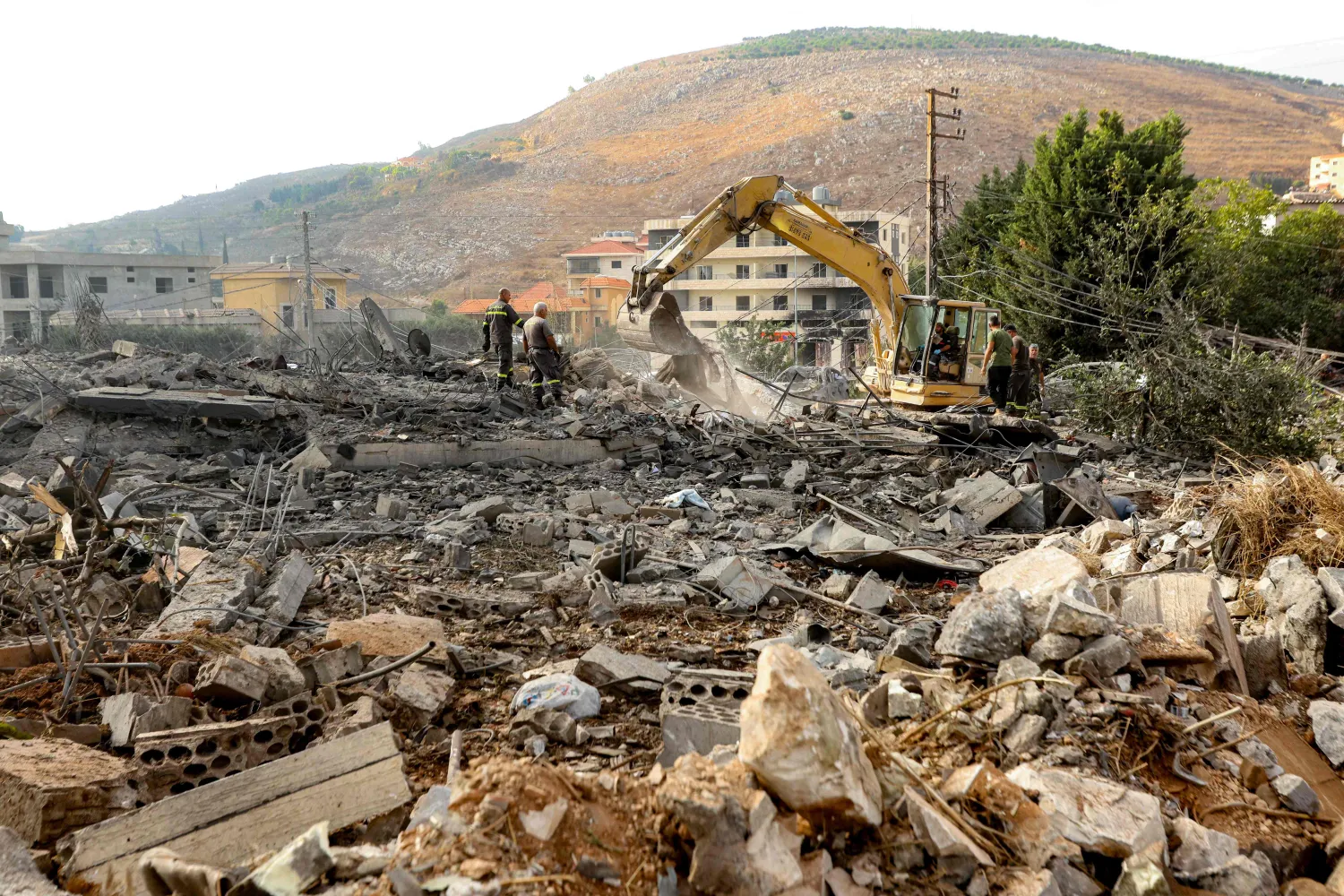 An excavator digs as rescuers search for survivors amidst the rubble following an overnight Israeli airstrike on the village of Kfar Rumman in southern Lebanon on September 7, 2026. (AFP) 