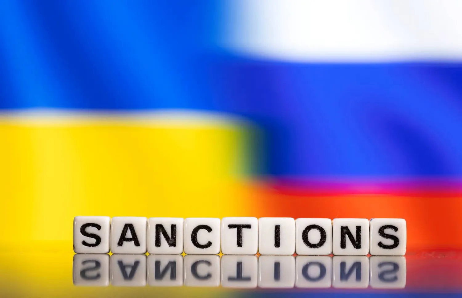 Plastic letters arranged to read "Sanctions" are placed in front of Ukraine's and Russia's flag colors in this illustration taken February 25, 2022. REUTERS/Dado Ruvic/Illustration/ File Photo