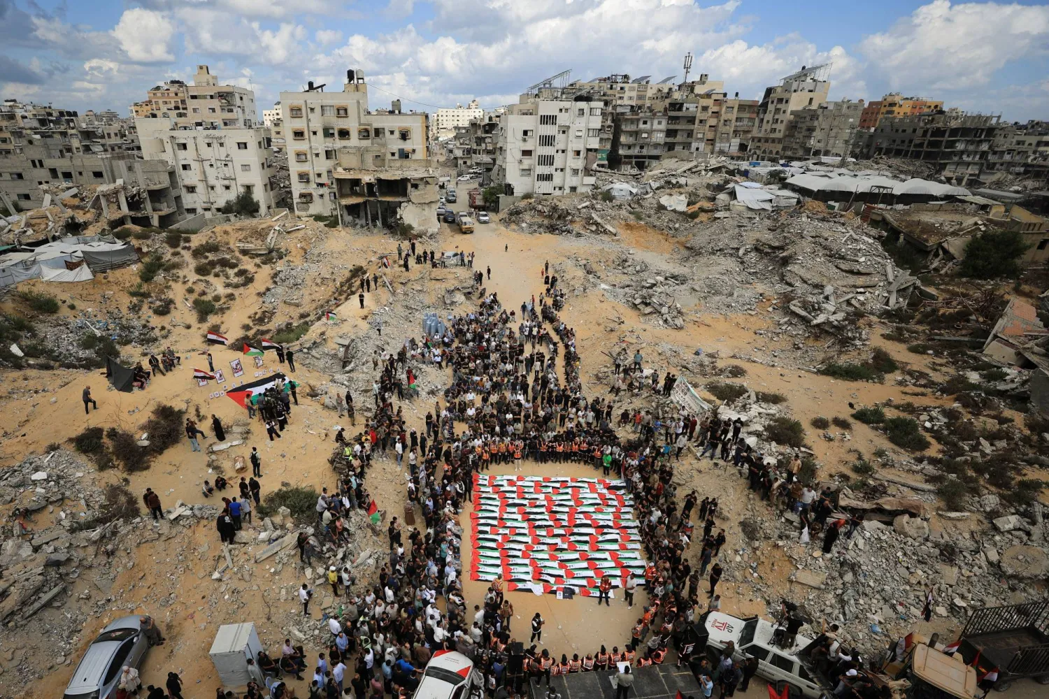 مشيعون يحضرون جنازة جماعية لفلسطينيين انتُشلت جثامينهم من تحت أنقاض مبنى سكني تعرض لضربة إسرائيلية في أكتوبر 2023 -وفقاً للدفاع المدني- وذلك في مدينة غزة اليوم (رويترز)