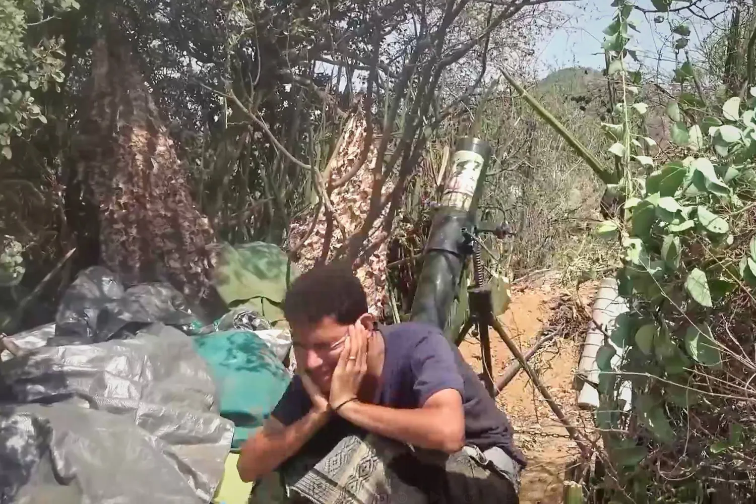 عنصر حوثي يغلق أذنيه خلال إطلاقه قذيفة هاون حيث تكثف الجماعة هجماتها على جبهات تعز (أ.ب)