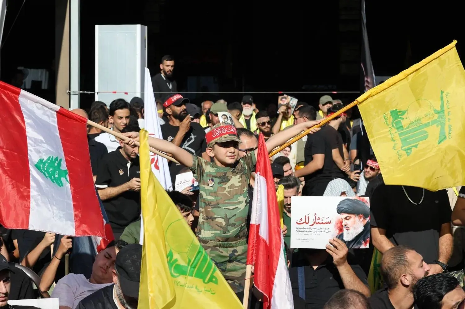 Hezbollah supporters carry Lebanese and Hezbollah flags during a commemoration marking the second anniversary of the assassination of the group’s former secretary-general, Hassan Nasrallah (EPA)