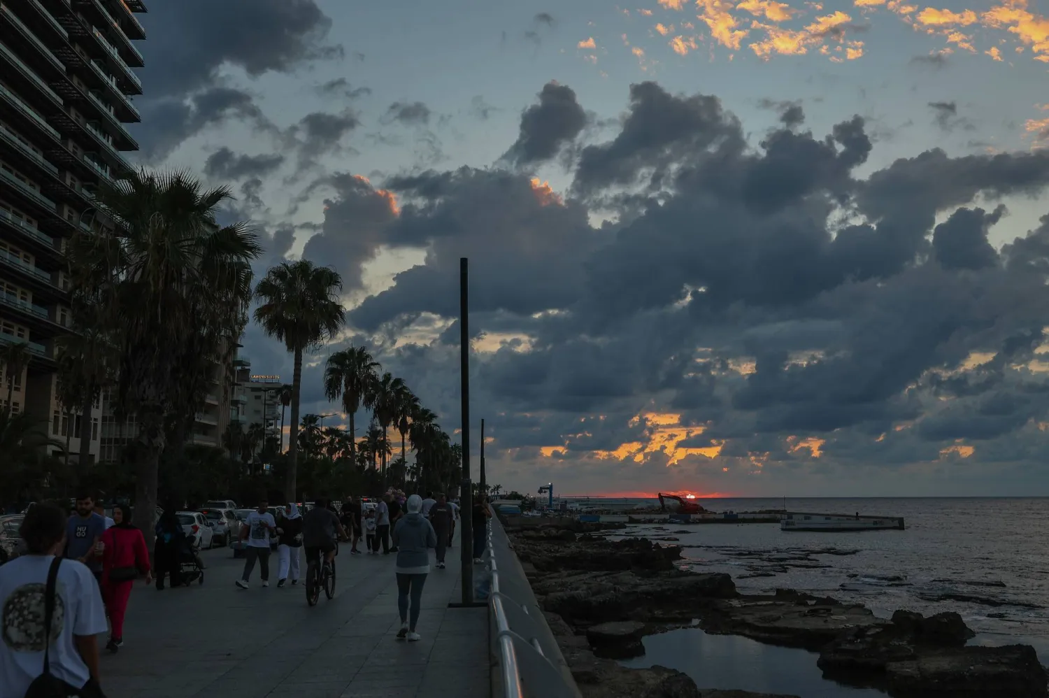 People walk along the Corniche Al-Manara seafront promenade on the coast of the Mediterranean Sea as the sun sets in Beirut, Lebanon, 30 September 2026. (EPA)