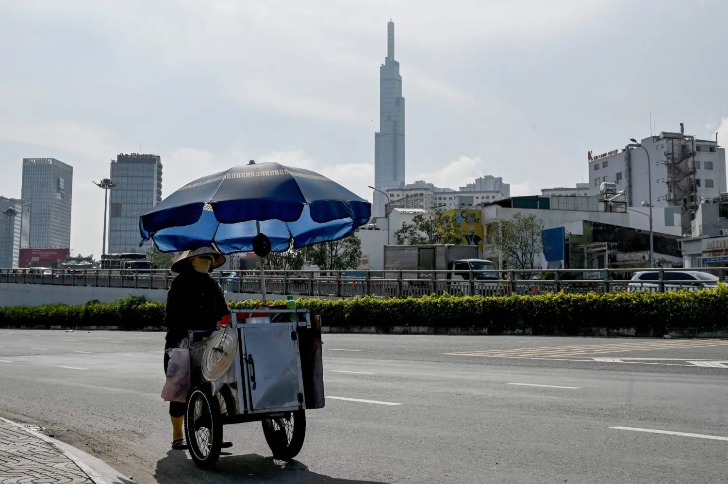 A street food vendor pushes a cart along the road in Ho Chi Minh City on October 2, 2026. (Photo by Nhac NGUYEN / AFP)