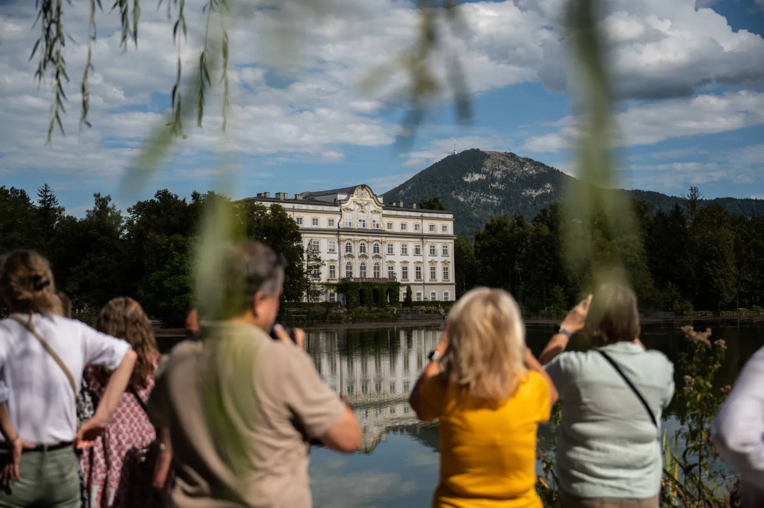 يلتقط زوارٌ صوراً لفندق «شلوس ليوبولدسكرون» (Schloss Leopoldskron) في سالزبورغ بالنمسا والذي استُخدم مقراً لإقامة عائلة «فون تراب» بفيلم «صوت الموسيقى» (The Sound of Music) (إسكندر خليف - نيويورك تايمز)