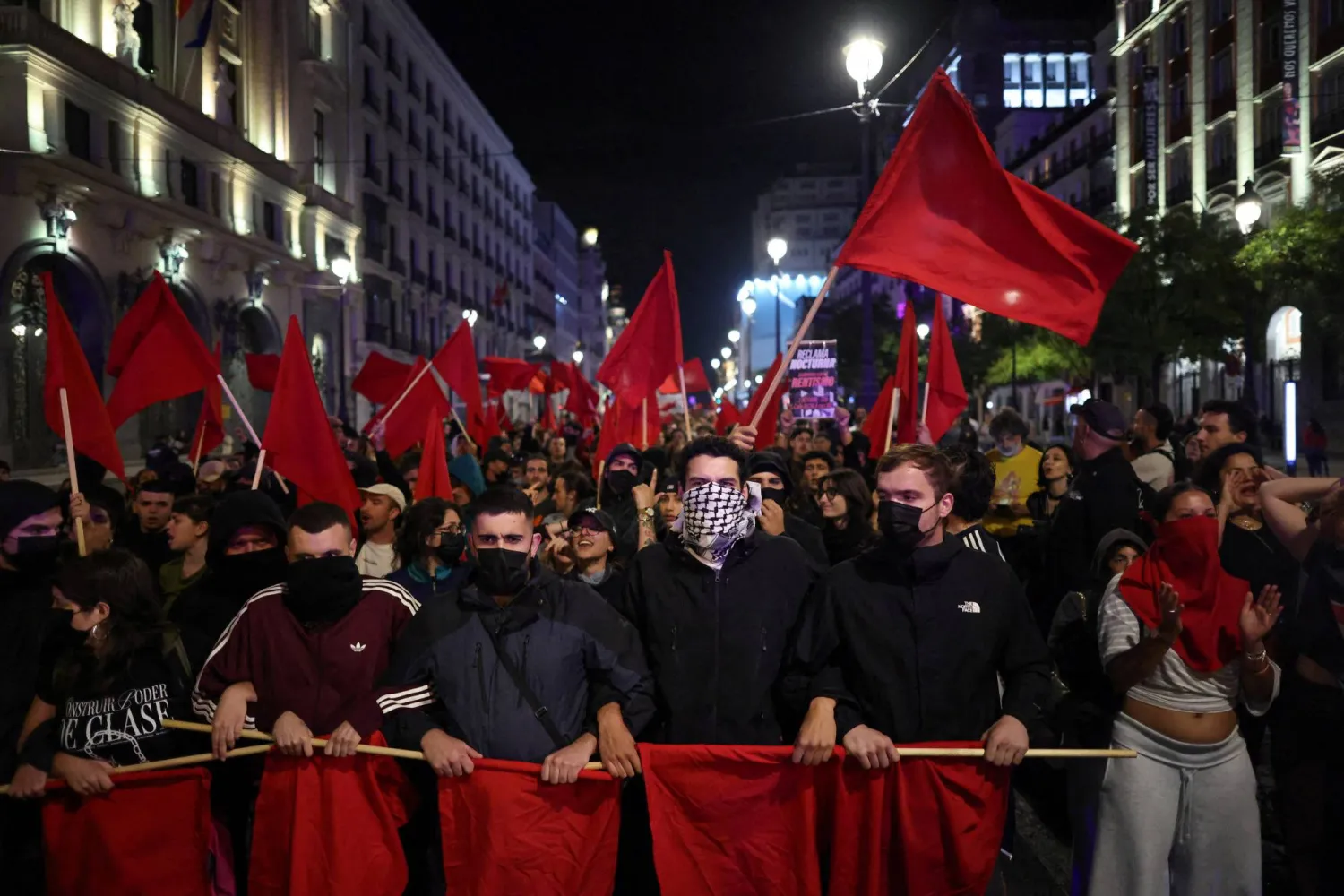 Demonstrators carry red flags during a march which began in Puerta del Sol square, where a protest camp has been set up, demanding political action to stop evictions and address the housing crisis, following the eviction of an 87-year-old woman from her home, in Madrid, Spain, October 2, 2026. REUTERS/Alejandro Martinez Velez 

