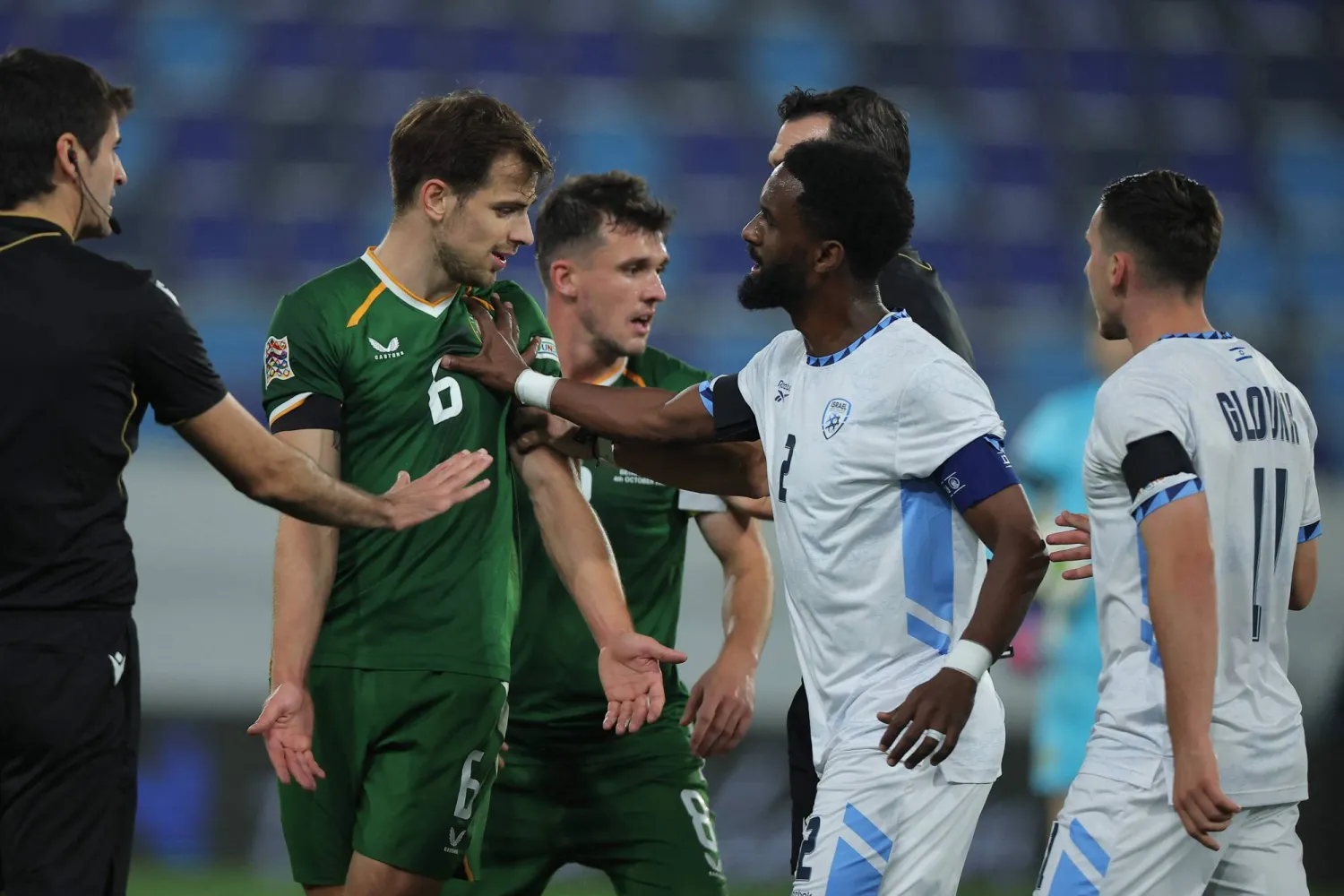 إيلي داسا لاعب إسرائيل يدفع جيسون مولومبي لاعب آيرلندا خلال مواجهة المنتخبين (أ.ف.ب)