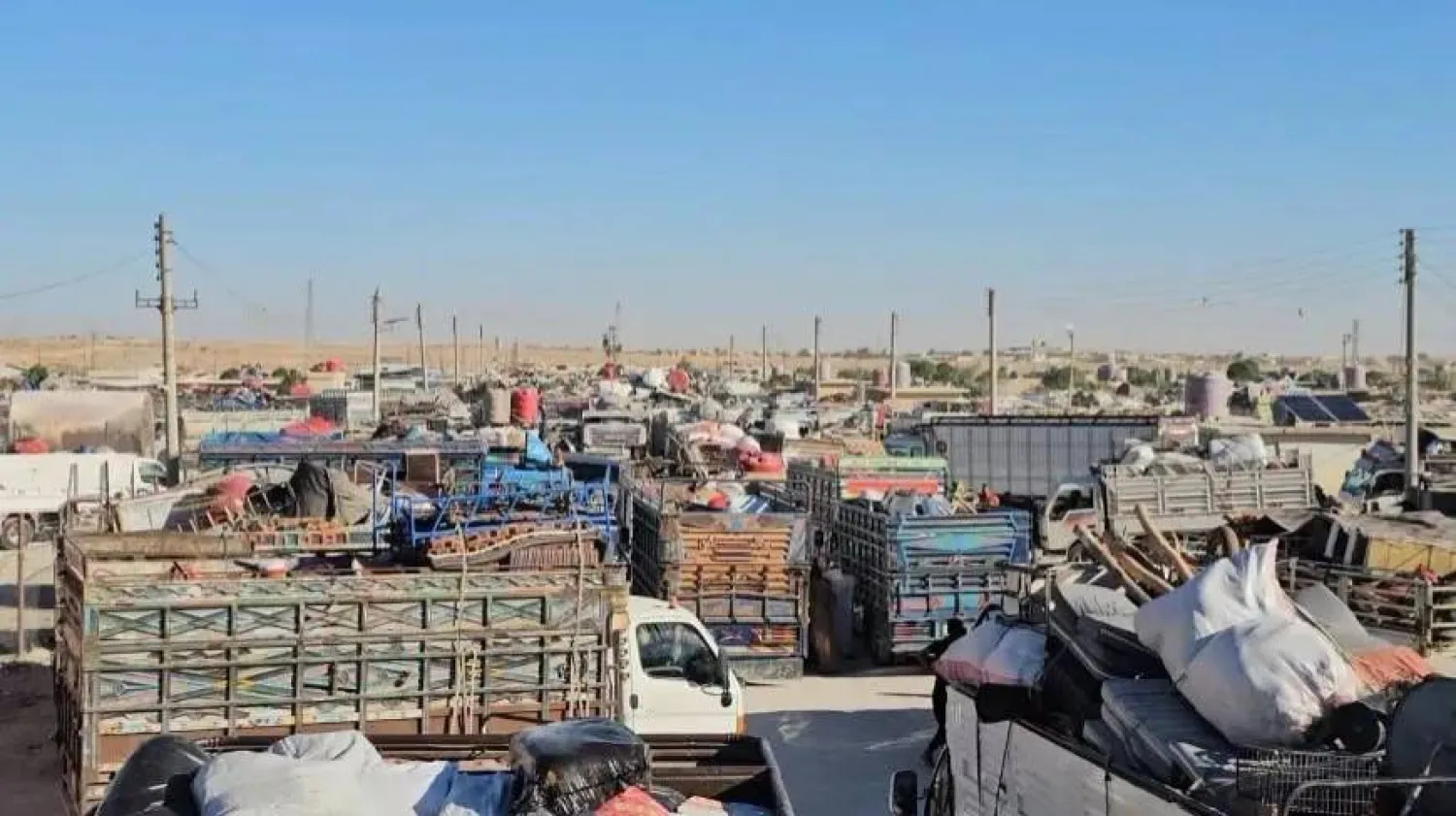 تأمين متعلقات العائدين في القافلة الثالثة قبيل الانطلاق إلى رأس العين من مخيم واشكاني في الحسكة (مركز رأس العين الإعلامي)