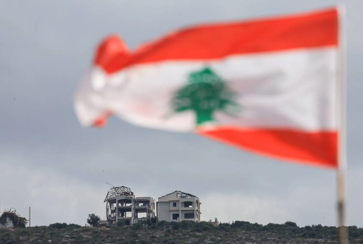 A Lebanese flag flies as buildings lie in ruins in Mansouri, as seen from Henniye, Lebanon, September 29, 2026. (Reuters)