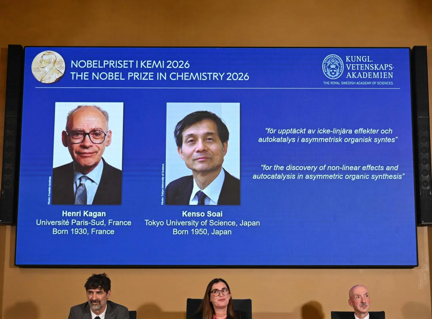 Kimya Nobel Komitesi Başkanı Heiner Linke, İsveç Kraliyet Bilimler Akademisi Genel Sekreteri Ellen Moons ve Kimya Nobel Komitesi üyesi Peter Somfai, bu yılın ödül sahipleri Fransa’dan Henri Kagan ile Japonya’dan Kensu Sway’ın fotoğraflarının ekranda gösterildiği sırada (AFP)