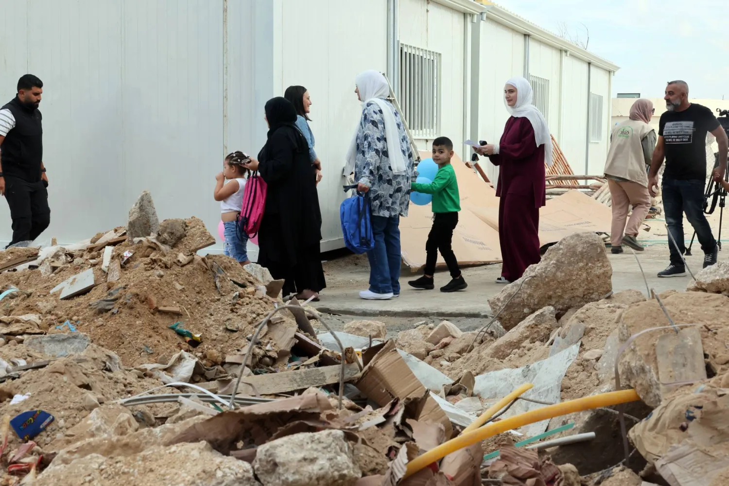 أطفال يغادرون برفقة ذويهم الفصول الدراسية المؤقتة في مدرسة «برج قلاوية» المتوسطة جنوب لبنان (إ.ب.أ)