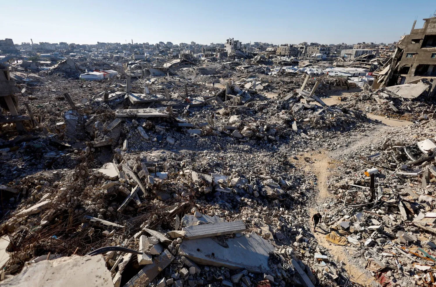 A Palestinian walks amid the rubble of buildings destroyed during the war in Gaza City, October 7, 2026. (Reuters)