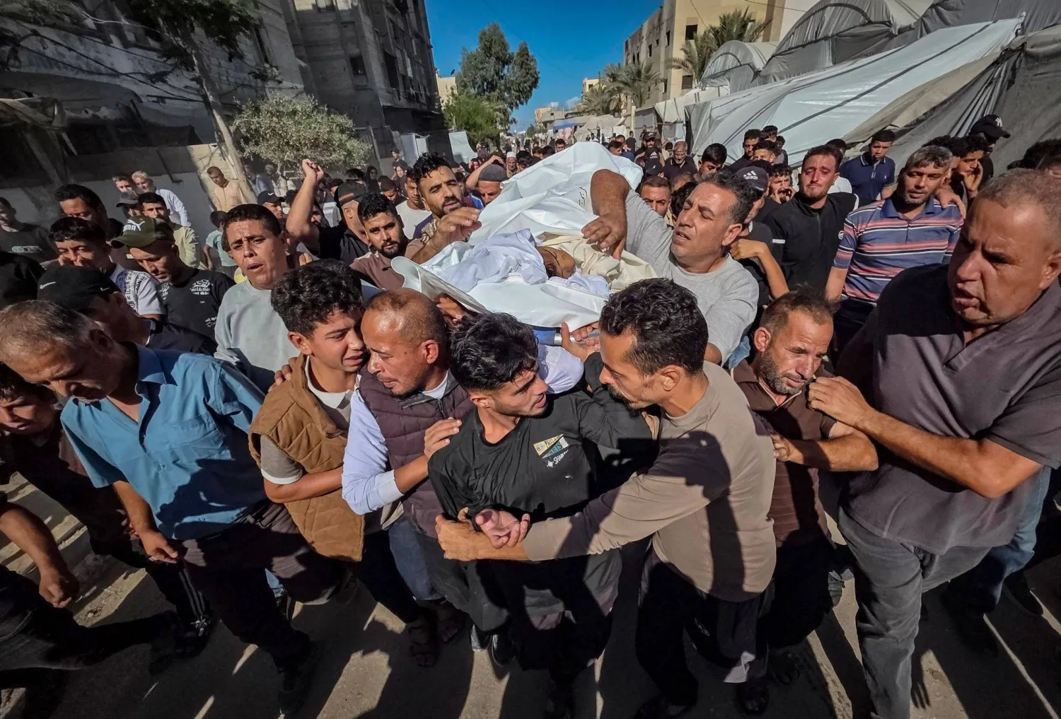 فلسطينيون يحضرون جنازة طفل ١٤ عاماً في مجمع ناصر الطبي بخان يونس بعد وفاته متأثراً بجراحه إثر إصابته برصاصة قالت عائلته إنها أُطلقت من الجانب الإسرائيلي قرب خيمتهم في وسط المدينة (د.ب.أ)