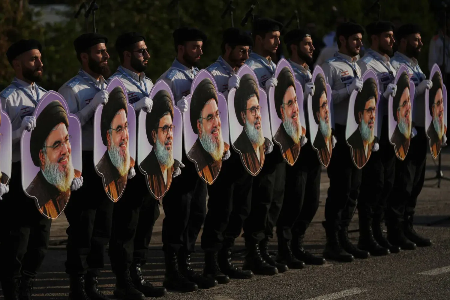 Mehdi İzcileri, suikastlarının ikinci yıldönümünde, Hizbullah’ın eski Genel Sekreteri Hasan Nasrallah ile onun halefi olarak aday gösterilen Haşim Safiyuddin’in fotoğraflarını tutuyor. (AP)