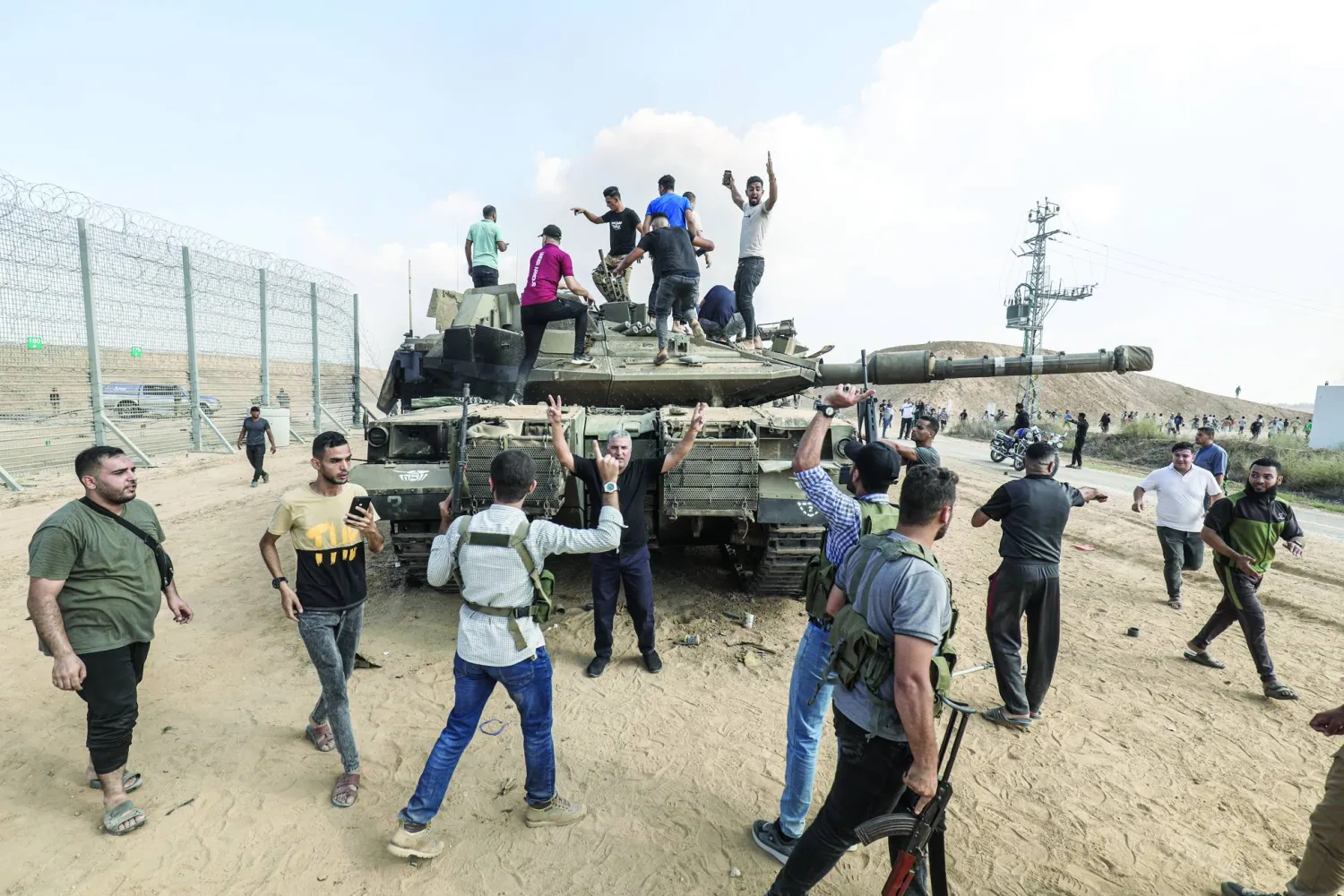 فلسطينيون في خان يونس يعتلون مركبة عسكرية إسرائيلية تم الاستيلاء عليها ضمن عملية «طوفان الأقصى» (د.ب.أ)