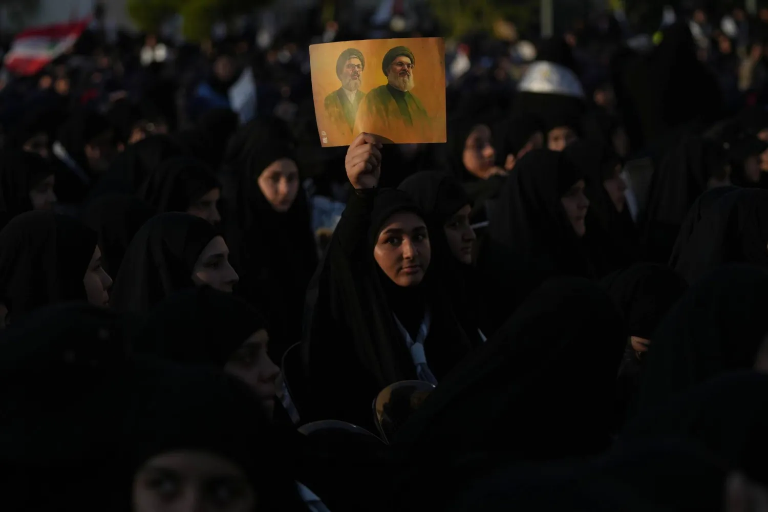 مناصرات لـ«حزب الله» يرفعن صورة لأمينيه العامين السابقين حسن نصر الله وهاشم صفي الدين في الذكرى الثانية لاغتيالهما في ضاحية بيروت الجنوبية (أ.ب)