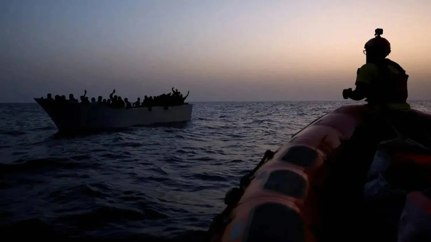 Migrants give signals to NGO Proactiva Open Arms Uno rescue boat in central Mediterranean Sea, August 17, 2022. (Reuters)

