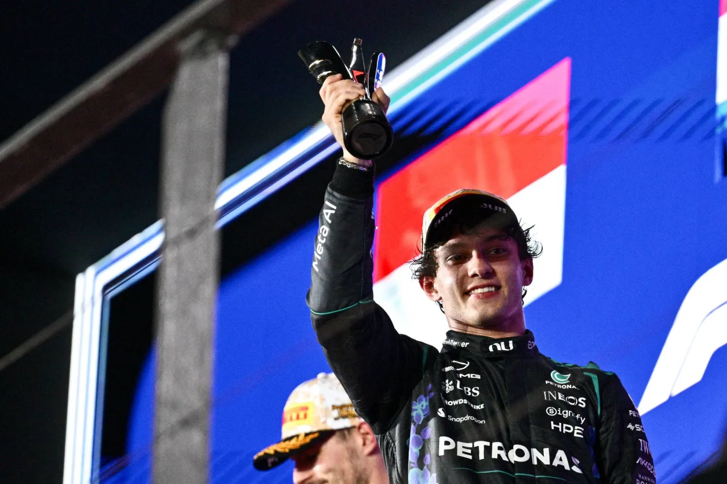  Third-placed Mercedes' Italian driver Kimi Antonelli lifts his trophy as he celebrates on the podium after the Formula One Singapore Grand Prix at the Marina Bay Street Circuit in Singapore on October 11, 2026. (AFP) 